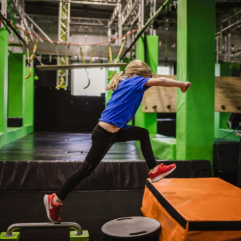 Kid jumping through ninja course